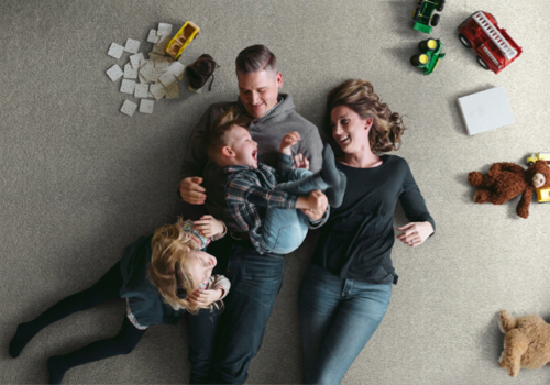 After-Carpet-Installation Family laying on new carpet flooring | Randy's Flooring